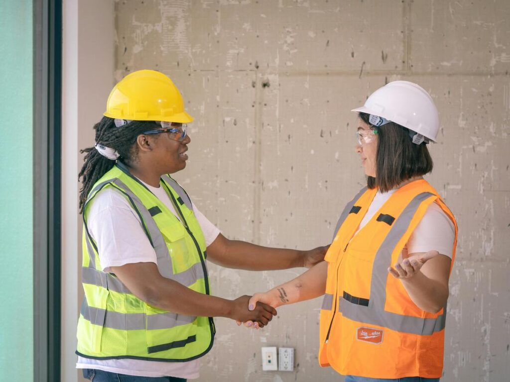 Two women in PPE shaking hands