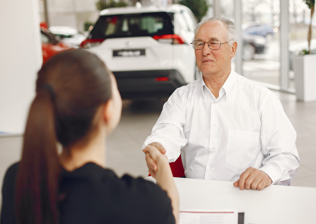 An old man shaking hands of the insurance agent