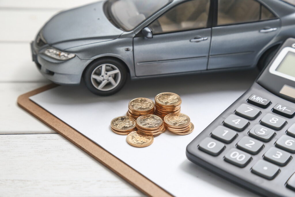 El automóvil y las monedas en la mesa representan el concepto de seguro